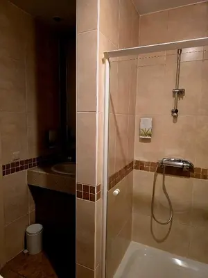 a bathroom with a shower with a tub and a sink at Hotel De Notelaer in Bornem