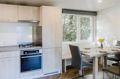 a kitchen with a dining table and a stove at Camping Baalse Hei in Turnhout