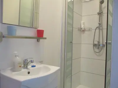 a bathroom with a sink and a shower at Hotel de la Gare Aalst in Aalst
