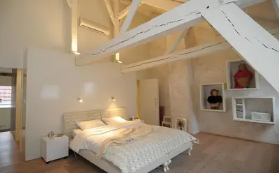 a bedroom with a large bed in a loft at Chambreplus Kriski in Ghent