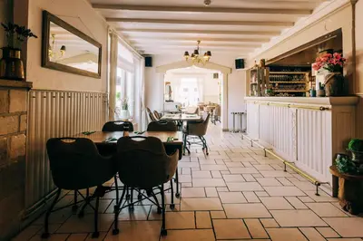 a restaurant with tables and chairs in a room at Hotel De Kalvaar in Ninove