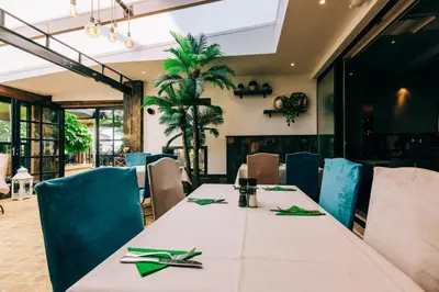 a dining room with a table with green napkins at Hotel De Kalvaar in Ninove