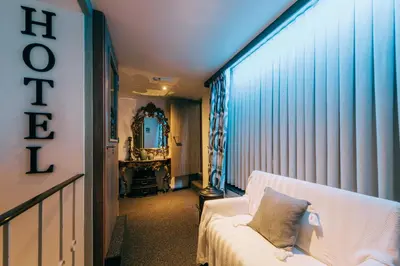 a living room with a white couch and a mirror at Hotel De Kalvaar in Ninove