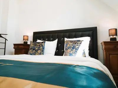 a bedroom with a bed with a black headboard and pillows at Logies Hanssen in Beveren