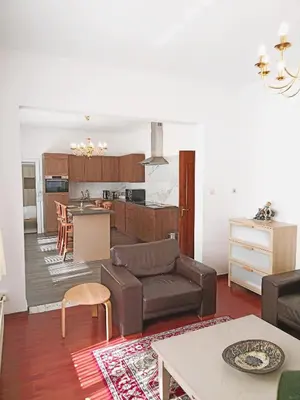 a living room with a couch and a kitchen at Logies Hanssen in Beveren