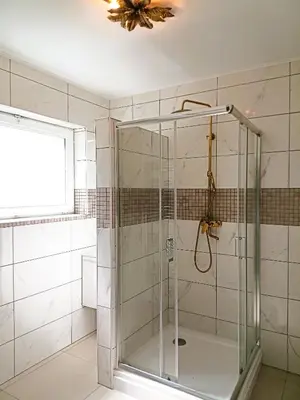 a glass shower in a bathroom with a ceiling at Logies Hanssen in Beveren