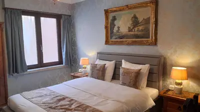 a bedroom with a bed and a painting on the wall at Logies Hanssen in Beveren