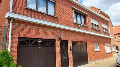 a red brick building with two garage doors at Logies Hanssen in Beveren