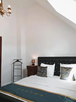 a bedroom with a bed with white sheets and pillows at Logies Hanssen in Beveren