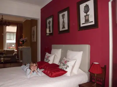 a little child laying on a bed with red pillows at Apartments Suites in Antwerp in Antwerp