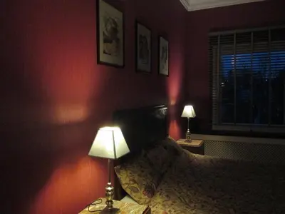 a bedroom with a bed with two lamps and a window at Apartments Suites in Antwerp in Antwerp