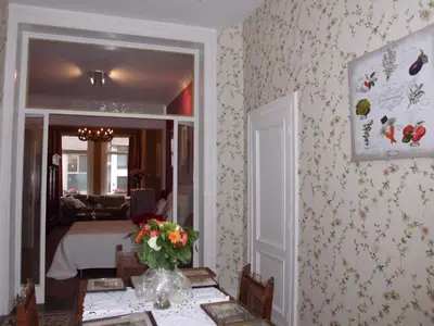 a room with a bed and a table with a vase of flowers at Apartments Suites in Antwerp in Antwerp