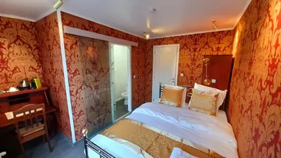 a bedroom with orange walls and a bed in it at Bosdam Budget Rooms in Beveren