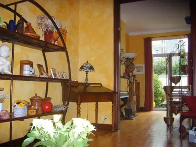 a living room with a table andcellaneous items on shelves at B&B Marianne in Brussels
