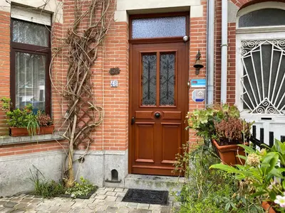a brown door on a brick house with plants at B&B Marianne in Brussels