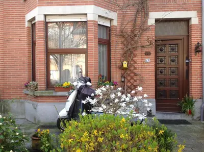 a scooter parked in front of a building with flowers at B&B Marianne in Brussels