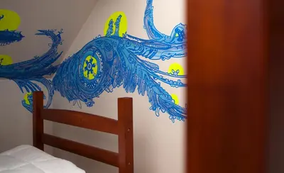 a bedroom with a blue and white wall at KaBa Hostel in Ghent