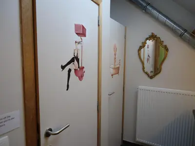 a bathroom with a door with hanging pots and pans at KaBa Hostel in Ghent