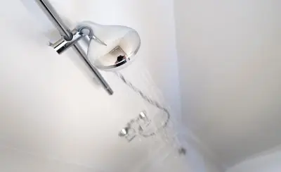 a shower with a shower head on a wall at KaBa Hostel in Ghent