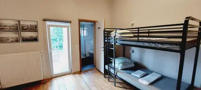 a room with two bunk beds and a bathroom at KaBa Hostel in Ghent