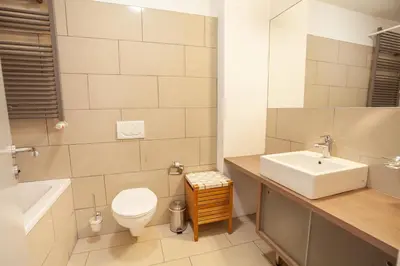 a bathroom with a sink and a toilet and a tub at Luxury Suites Castel by Rikas Hotels in Antwerp