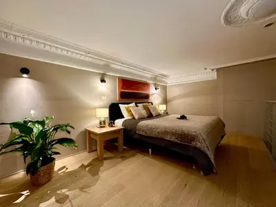 a bedroom with a bed and a potted plant at Luxury Suites Castel by Rikas Hotels in Antwerp