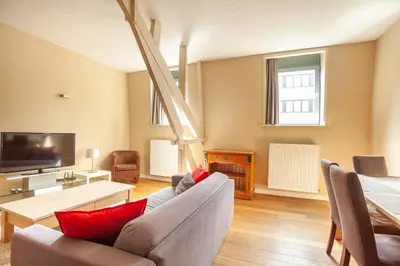 a living room with a couch and a tv at Luxury Suites Castel by Rikas Hotels in Antwerp