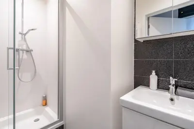 a white bathroom with a shower and a sink at Beautiful Cozy Apartments in the Heart of Antwerp in Antwerp