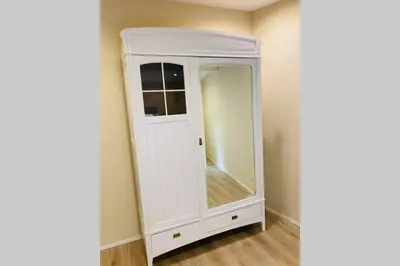 a white cabinet with a mirror in a room at Cosy house in a charming village in Beauvechain