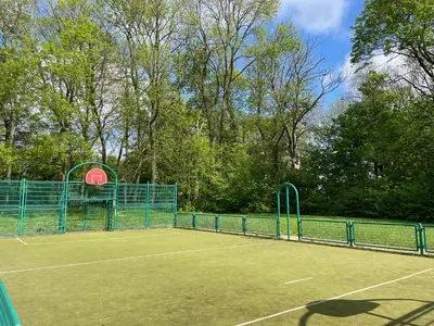 a tennis court with a fence on top of it at Cosy house in a charming village in Beauvechain
