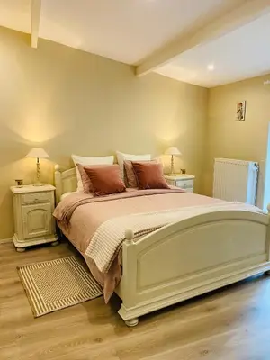 a bedroom with a large bed with two night stands at Cosy house in a charming village in Beauvechain