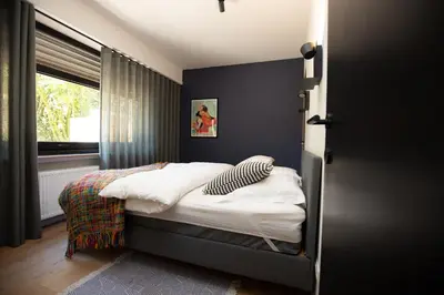 a bedroom with a bed and a window at Vakantiehuis Ochtendgloren in Turnhout