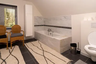 a bathroom with a tub and a toilet at Vakantiehuis Ochtendgloren in Turnhout