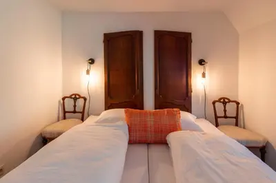 a bedroom with two beds and two chairs at Vakantiehuis Ochtendgloren in Turnhout