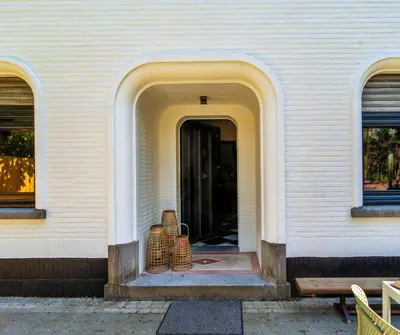 an entrance to a building with baskets on the steps at Vakantiehuis Ochtendgloren in Turnhout