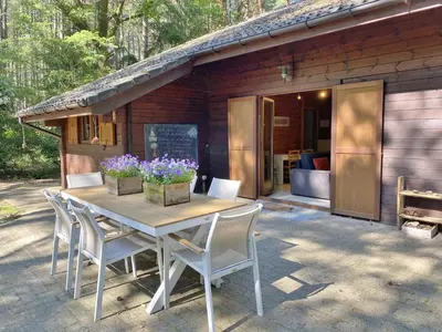 a table and chairs in front of a cabin at Boshuisje in Lille