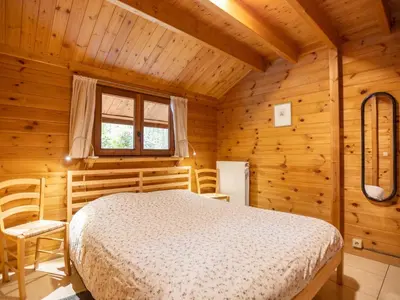 a bedroom with a bed in a wooden room at Boshuisje in Lille