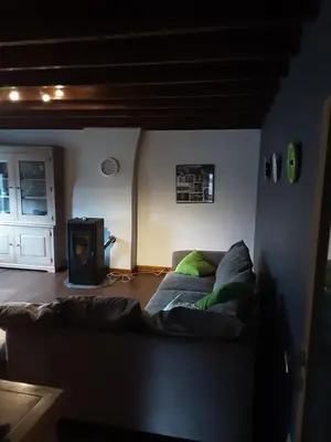 a living room with a couch and a stove at ’t Wielerpension in Steenhuize-Wijnhuize