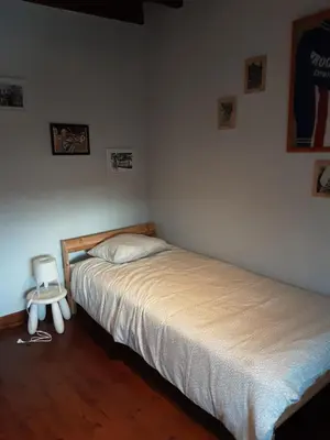 a bedroom with two beds and a chair in it at ’t Wielerpension in Steenhuize-Wijnhuize