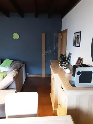 a living room with a couch and a desk with a microwave at ’t Wielerpension in Steenhuize-Wijnhuize