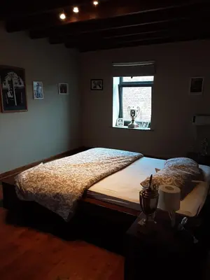 a bedroom with a large bed with a window at ’t Wielerpension in Steenhuize-Wijnhuize