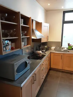 a kitchen with a microwave on top of a counter at ’t Wielerpension in Steenhuize-Wijnhuize