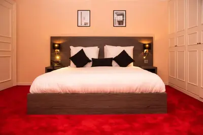 a bedroom with a large white bed with black pillows at La Bourse Hotel in Brussels