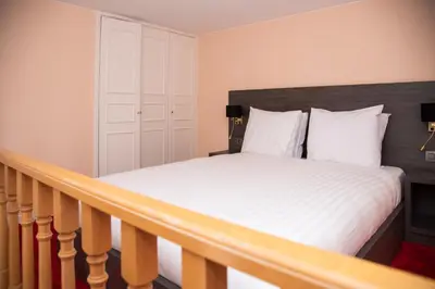 a bedroom with a bed with white sheets at La Bourse Hotel in Brussels