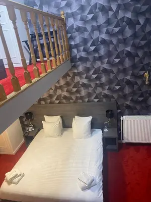 a bed in a room with a staircase at La Bourse Hotel in Brussels