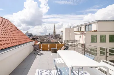 a balcony with tables and chairs and a view of the city at THE GOOD FLATS in Brussels