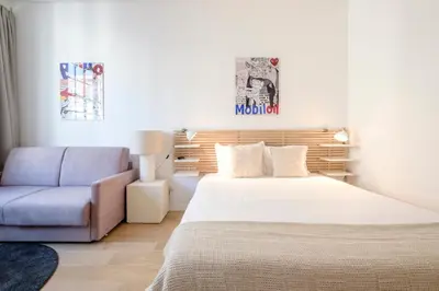 a bedroom with a bed and a couch and a chair at THE GOOD FLATS in Brussels