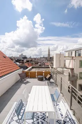 a balcony with chairs and tables on a roof at THE GOOD FLATS in Brussels