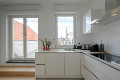 a kitchen with white cabinets and a large window at THE GOOD FLATS in Brussels