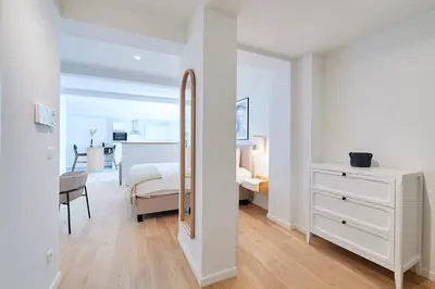 a white bedroom with a white dresser and a mirror at THE GOOD FLATS in Brussels
